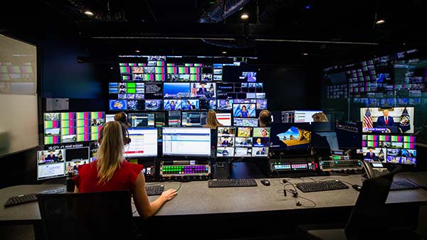 Employees study screens in a broadcast TV control room