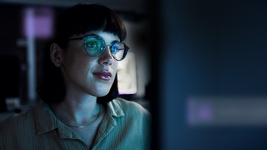 one woman’s face lit up by monitor with a verified update notification over image