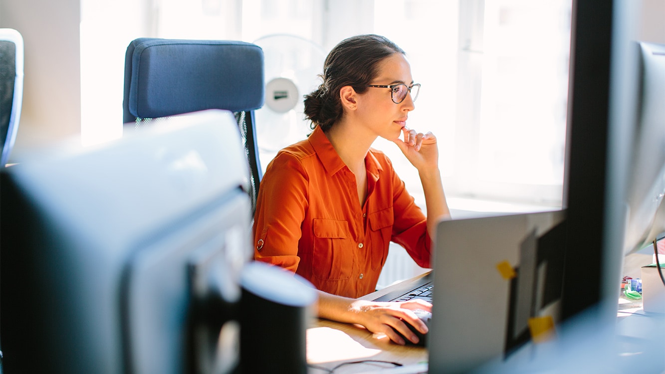 Shot of business woman sitting at her desk and working on desktop computer